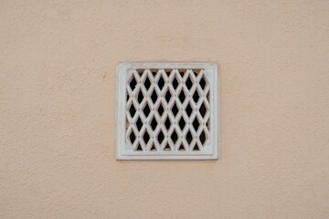 retro ventilation grille on wall, plaster background