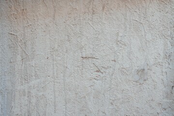 Textured Plaster Wall Background. A close-up of a textured plaster wall with an abstract rough surface. The neutral light beige color and irregular patterns create a natural and artistic backdrop. 