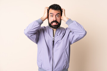 Caucasian man with beard wearing a jacket over isolated background doing nervous gesture