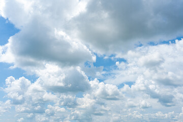 Fluffy white clouds drift across a clear blue sky, creating a breathtaking cloudscape