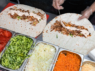 Crafting delicious chicken shawarma wraps with fresh ingredients and creamy sauce