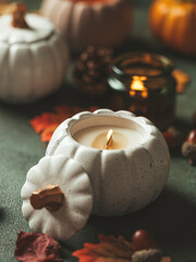 Handmade candles made of coconut and soy wax in a concrete, plaster candlestick with a wooden wick. Scented candle in a pumpkin-shaped candlestick. Selective focus