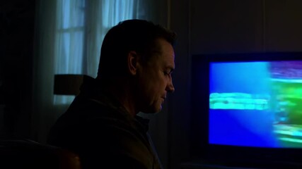 Watching a thrilling football match alone on a cozy evening at home