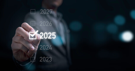 Businessman hand tick correct sign mark to 2025 year for preparation merry Christmas and happy new year concept.