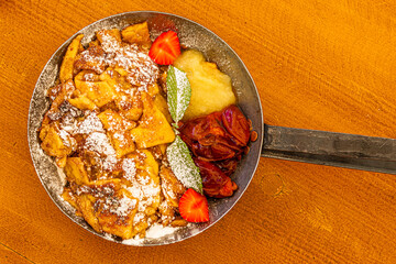 Kaiserschmarrn with fresh strawberries and powdered sugar