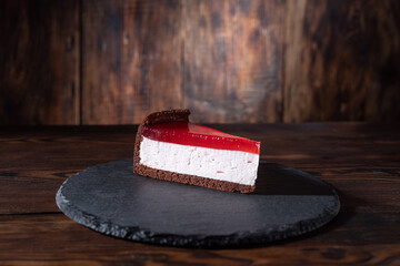 Cheesecake with red marmalade. Cake on a slate tray. A piece of cake with marmalade.