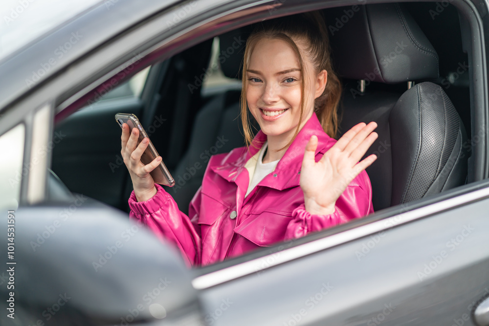 Wall mural Young pretty girl inside a car using mobile phone