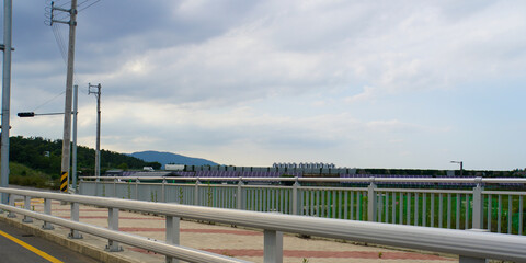 Scenic view of a bridge spanning across a landscape with a cloudy sky overhead, providing a sense of journey and openness