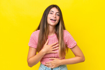 Young caucasian woman isolated on yellow background smiling a lot