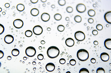 Closeup of raindrops on a clean glass surface. Wet surface theme