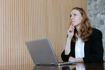 Businesswoman Deep in Thought While Working on Laptop: Decision-Making, Critical Thinking, and...