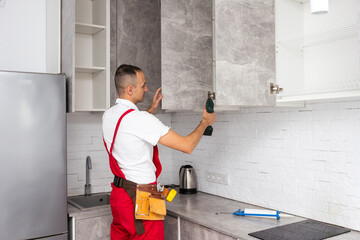 Workers installing new stylish furniture in kitchen