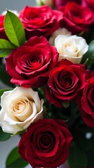 Obraz premium Dense Bouquet Featuring a Vibrant Contrast of Red and White Roses, With Lush Green Leaves Peeking Through the Petals