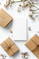 Brown gift boxes tied with twine surrounded by delicate flowers on a white background for a natural themed celebration. Copy space.