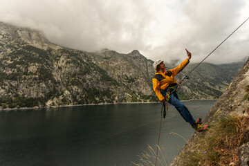 A man is taking a selfie while rock climbing