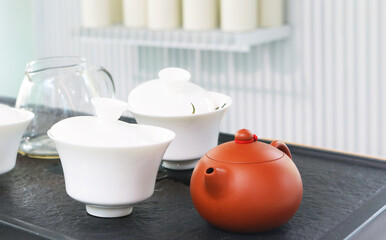 Red clay teapot on table background.