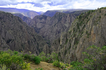 view of the steep, eroded cliffs of the black canyon national park, near gunnison, colorado, on a stormy day, from tomichi point