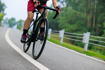 Asian woman cycling at summer park