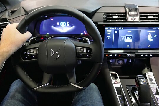Multifunction driving wheel and dashboard of modern french premium crossover SUV DS7 Antoine De Saint Exupery edition with hand of driver on it. Displayed on car expo in Nitra, Slovakia, october 2024