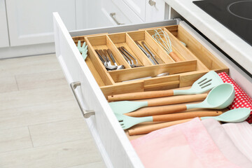 Box with cutlery in drawer, closeup. Kitchen utensils storage