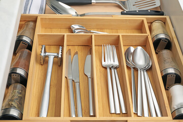 Box with cutlery in drawer, closeup. Kitchen utensils storage