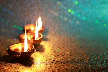 Diwali celebration. Diya lamps on color background. Space for text