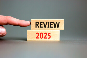 Planning review 2025 new year symbol. Concept words Review 2025 on beautiful wooden blocks. Beautiful grey background. Businessman hand. Business review 2025 new year concept. Copy space.