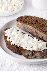 Rye bread with cottage cheese on a white table