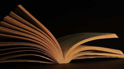 open book on black. old book open on dark background. mystical nuance. history book. story, tale, fairy tale