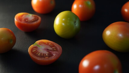 several tomatoes on a black background