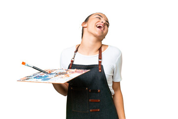 Young artist woman holding a palette over isolated chroma key background laughing