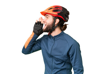 Young cyclist man over isolated chroma key background shouting with mouth wide open to the lateral