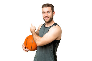 Obraz premium Handsome young man playing basketball over isolated chroma key background pointing back