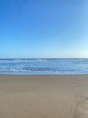 beach with calm waves and blue skies
