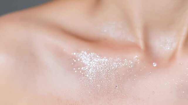 woman collarbone, highlighted with shimmering glitter, emphasizing a delicate and glowing skin texture.