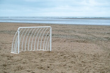 small metal soccer goal on a lonely beach