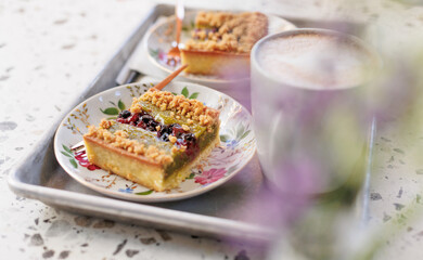 nut cake with pistachio pieces on a beautiful plate. dessert and coffee for two.