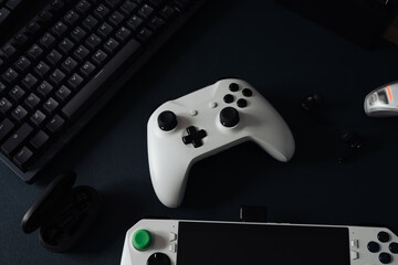 gamer work space concept, top view a gaming gear, mouse, keyboard, game controller, headset, in ear headphone and mouse pad on black table background.
