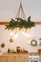 Kitchen with a Christmas wreath on the wall and a hanging lamp with fir branches