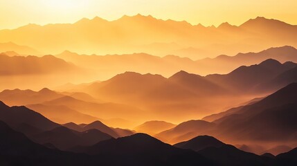 Obraz premium Stunning golden sunrise illuminating mountain ranges with layered silhouettes across the horizon at dawn