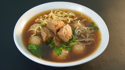 a typical Indonesian food called Bakso or Baso in a bowl on a black background