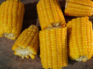 several pieces of boiled corn on a blue plate on the table. flat lay. theme of healthy eating and diet. boiled corn (jagung rebus)