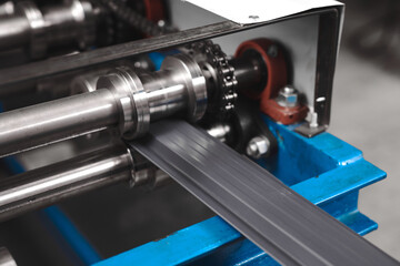 Rolled metal, metal processing and manufacturing of metal fence, close-up of metal rolling equipment at the factory