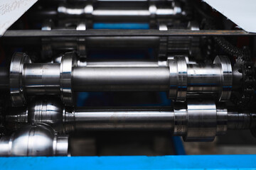 Rolled metal, metal processing and manufacturing of metal fence, close-up of metal rolling equipment at the factory