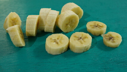 banana slices on a turquoise wooden board. healthy food theme, healthy lifestyle theme
