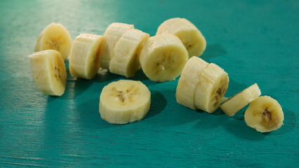 banana slices on a turquoise wooden board. healthy food theme, healthy lifestyle theme