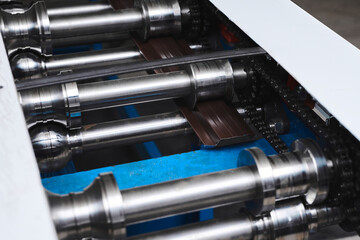 Rolled metal, metal processing and manufacturing of metal fence, close-up of metal rolling equipment at the factory