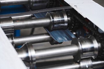 Rolled metal, metal processing and manufacturing of metal fence, close-up of metal rolling equipment at the factory