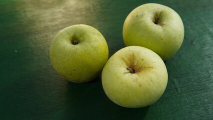 green apple fruit on a green wooden board. healthy food theme, healthy lifestyle theme