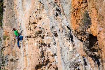 A rock climber ascends to the summit via a difficult route.